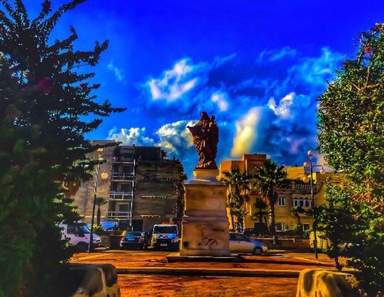 STATUE AGAINST CLOUDY SKY AT NIGHT