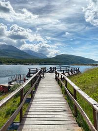 Wooden pier over lake against sky