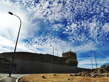 Low angle view of street light against cloudy sky