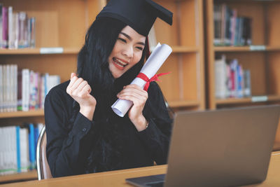 Portrait of young woman using mobile phone at home