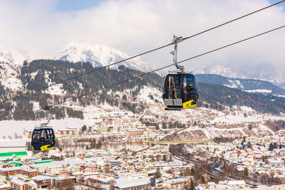 Overhead cable car on snowcapped mountains against sky