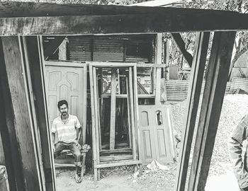 Portrait of man sitting by door