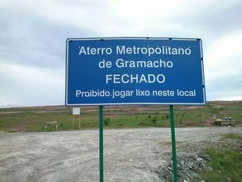 Road sign against cloudy sky