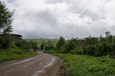 Road amidst trees against sky