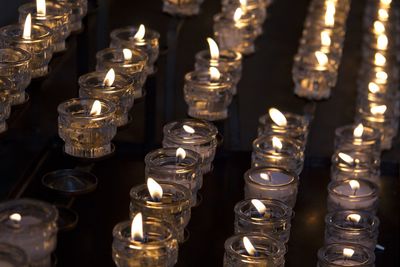 Lit candles in row against illuminated building