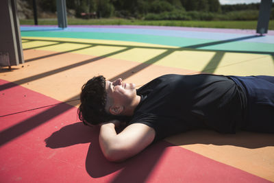 Young woman lying on colorful ground