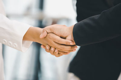 Midsection of couple holding hands