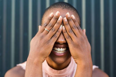 Close-up of laughing woman covering face
