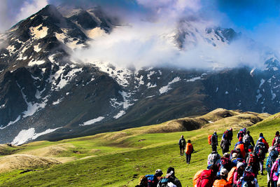 People on hill against mountains