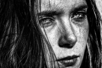 Close-up of young woman with freckle on face