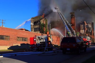 Rear view of firefighters working on street