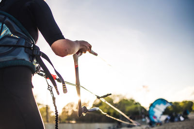 Low angle view of man holding rope against sky