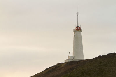 Lighthouse on mountain against sky