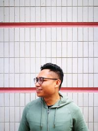 Young man standing against wall