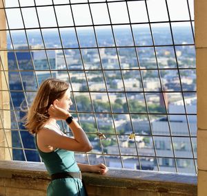 Side view of young woman looking at window