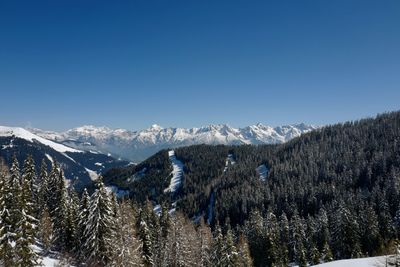 Scenic view of snowcapped mountains against clear blue sky