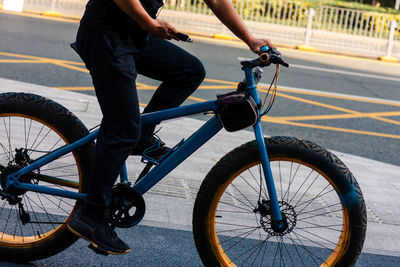Low section of person riding bicycle on road