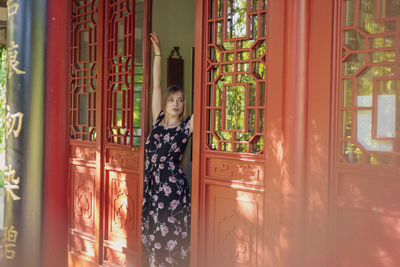 Portrait of woman standing by window