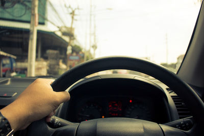 Cropped image of hand holding glass of car