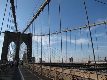 Suspension bridge against cloudy sky