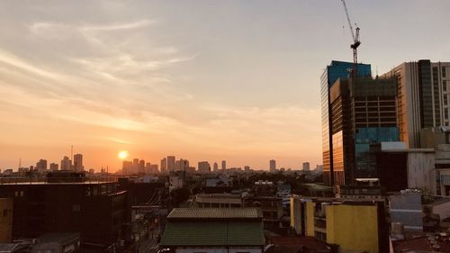 Modern buildings against sky during sunset