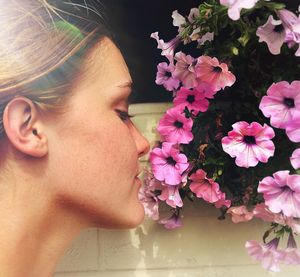 Close-up portrait of woman with pink flower