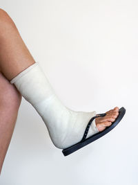 Low section of woman against white background