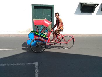 Portrait of young woman with bicycle on street