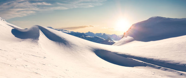 Scenic view of snowcapped mountains against sky during sunset