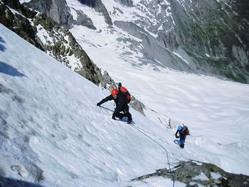 People skiing on snowcapped mountain against sky