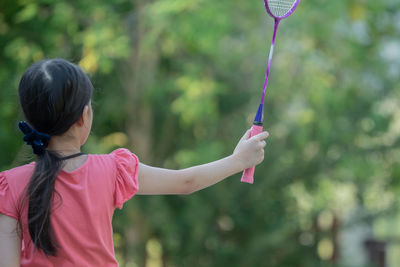 Rear view of girl holding badminton racket
