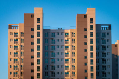 View of an apartment tower in front of a blue sky in south korea