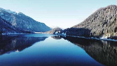 Scenic view of lake and mountains against clear sky