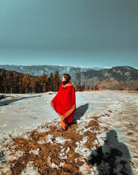 Man standing on snow covered mountain against sky