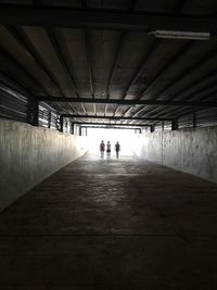 Rear view of man walking in tunnel