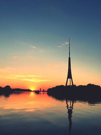 Silhouette sailboats in lake against sky during sunset