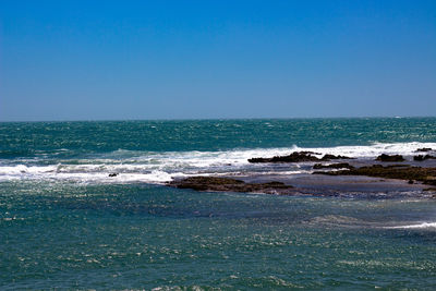 Scenic view of sea against clear blue sky