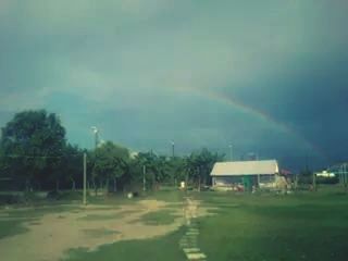 Scenic view of rainbow over landscape against sky