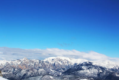 Scenic view of snowcapped mountains against clear blue sky