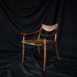Empty wooden chair against black textile