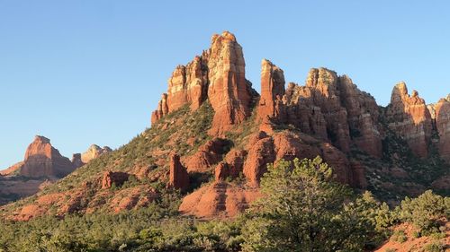 Low angle view of rock formations against clear blue sky