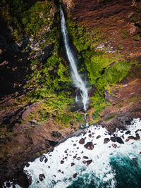 Aerial photo of waterfall by the atlantic ocean, madeira, portugal