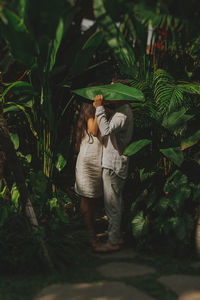 Rear view of women standing by plants