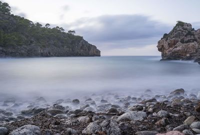 Scenic view of rocks on beach against sky