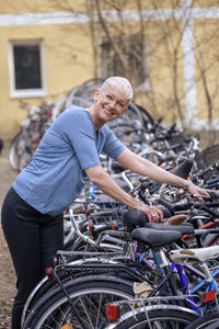 Portrait of smiling mature woman parking bicycle
