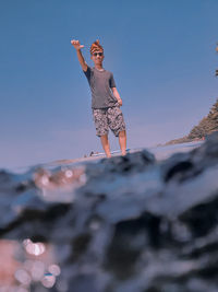 Low angle view of woman standing against sky