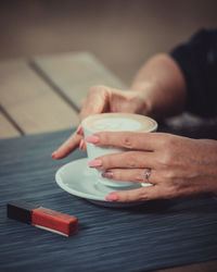 A woman is going to enjoy a morning cappuccino