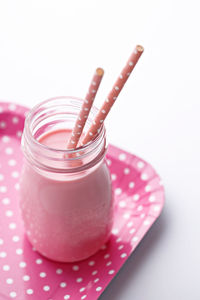 Close-up of pink jar against white background