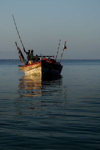 Fishing boat in sea against sky