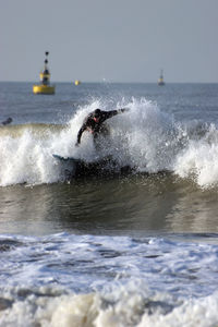 Waves splashing on sea against sky